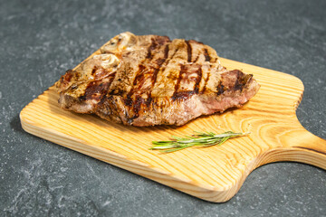 Juicy piece of grilled meat appetizingly displayed on a dark shale background