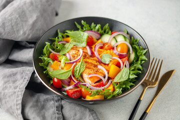 Easy salad of grilled salmon, fresh cucumber, tomato, sweet pepper, spinach leaves and onion . Healthy food.