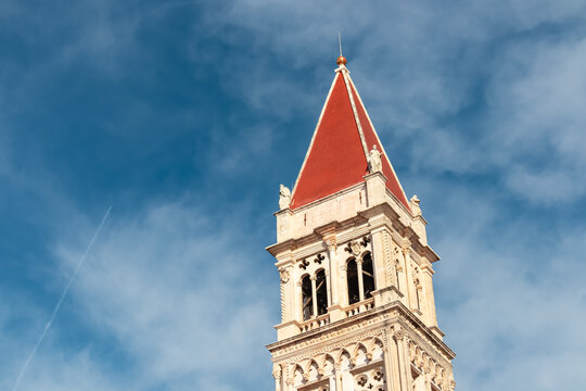 Imposing bell tower of Cathedral of St. Lawrence (San Lorenzo) against a dramatic sky in historic old town Trogir, Split-Dalmatia, Croatia, Europe. Tourist travel destination at Adriatic Sea. - Powered by Adobe