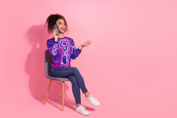 Full length photo of charming positive woman wear print sweatshirt talking modern gadget empty space isolated pink color background