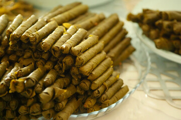 Homemade stuffed vine leaves are arranged in a row on the table,