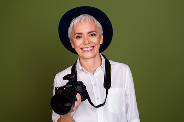 Photo of shiny attractive lady photographer dressed white shirt cap smiling filming camera empty space isolated khaki color background