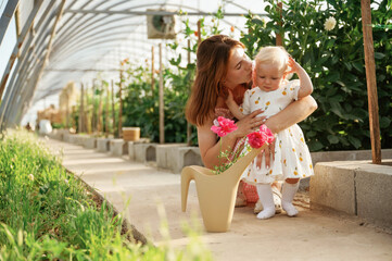 Mother and daughter are in the greenhouse