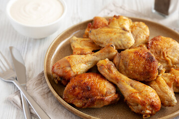 Homemade BBQ Chicken Drumsticks and Wings with Alabama White Sauce, side view.