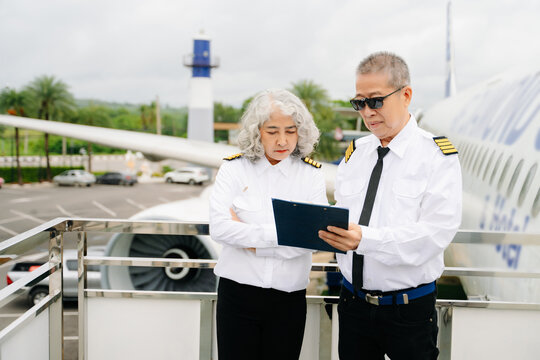 Mature commercial male pilot Beautiful middle aged woman airplane captain instructor has a meeting, discussion with aircrew team