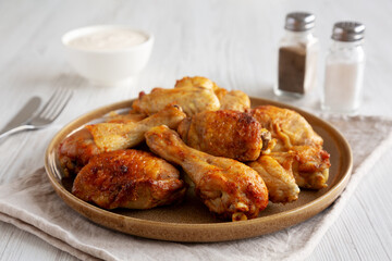 Homemade BBQ Chicken Drumsticks and Wings with Alabama White Sauce, side view.