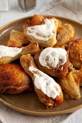 Homemade BBQ Chicken Drumsticks and Wings with Alabama White Sauce, side view.