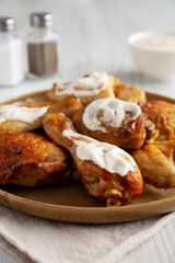 Homemade BBQ Chicken Drumsticks and Wings with Alabama White Sauce, side view.
