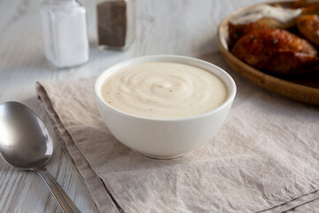 Homemade Alabama White Sauce for BBQ Chicken Drumsticks and Wings, side view.