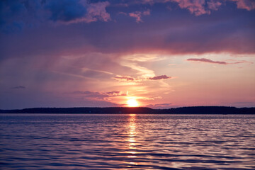 Obraz premium blurred background view of summer sunset with the reflection of the sun on the river