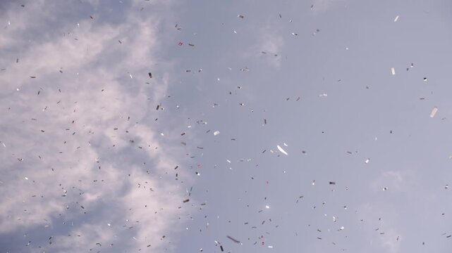 Confetti and small danish flags against a blue sky