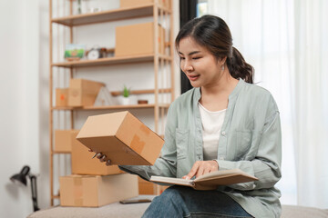 Young Woman Managing Her Online Selling Business from Home, Checking Inventory and Taking Notes