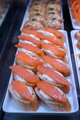 Delicious smoked salmon bites on cream cheese in the counter of a shop