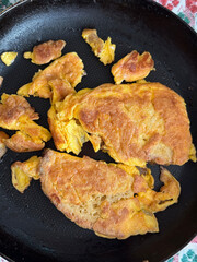 Close-up shot of scrambled eggs in a frying pan, depicting a homemade breakfast meal