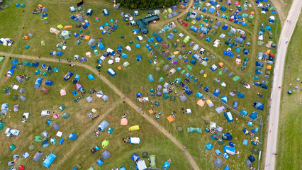 Drone photography of a tent city at music festival during summer day
