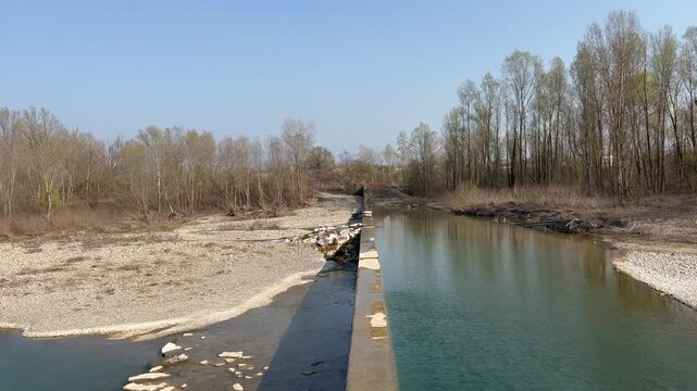 slow flow of the Enza river bed in Montecchio Emilia with barrier. High quality 4k footage