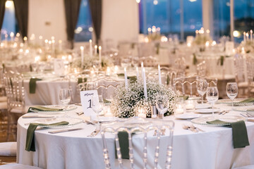 Elegant Wedding Reception Table Setting with Candles and Greenery at Evening Event
