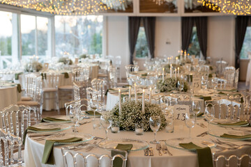 Elegant Wedding Reception Table Setting with Candles and Greenery at Evening Event