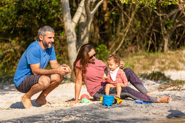 Young caucasian family having a picnic at the lake on a sunny afternoon.