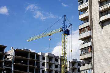 A tower crane at a house construction site.