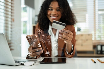 Happy businessman hand holding credit card and use laptop and smartphone in office.