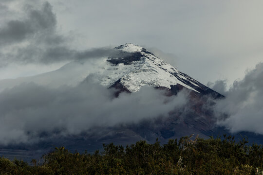 Cotopaxi Volcano (5,897 m) surrounded by clouds with its snow-capped summit in the Ecuadorian Andes