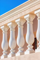 Fototapeta premium Elegant white balustrade and columns of classical building against clear blue sky