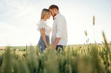 Lovely couple are on the green agricultural field together