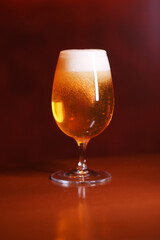 A glass of beer stands on the bar counter