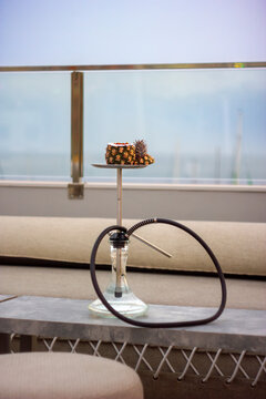 A hookah with a pineapple-shaped bowl, featuring an exotic and tropical design.
Un shisha con una cazoleta en forma de pi&ntilde;a, con un dise&ntilde;o ex&oacute;tico y tropical.