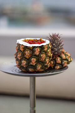 A hookah with a pineapple-shaped bowl, featuring an exotic and tropical design.
Un shisha con una cazoleta en forma de pi&ntilde;a, con un dise&ntilde;o ex&oacute;tico y tropical.