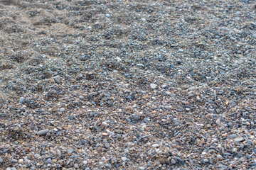 Gray small stones on sea pebble beach in Turkey, texture of stones, pebble surfaces,