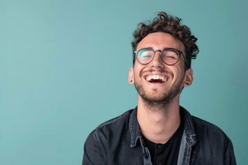 Obraz premium Young adult man laughing against solid color background