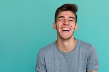 Fototapeta premium Young adult man laughing against solid color background