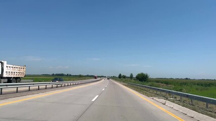 View from the driver's seat while driving on a highway. for themes related to travel, transportation, and road trips.
