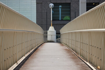 Obraz premium 夏の昼の都市の街の連絡通路の階段とバリアフリーの施設の様子