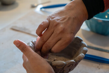shape clay with hands	
