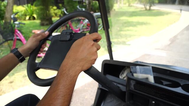 man driving an electric golf cart in a resort