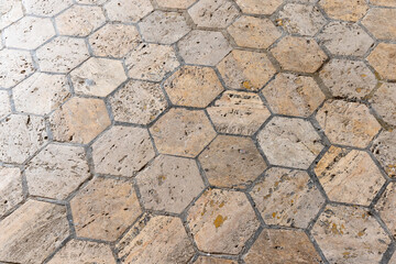Old stone flooring made of beige hexagon tiles, background photo