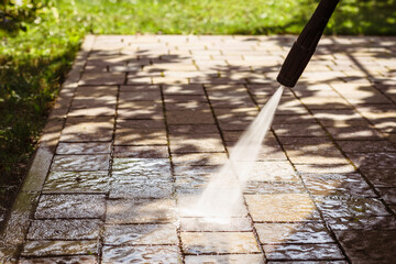 Washing Sidework Path by Pressure Washer with Landscaping Grass. Jet Washing or Pressure Cleaning...