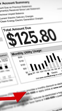 A close-up vertical view of a household electric utility bill rising. Increasing cost of living concept.  	