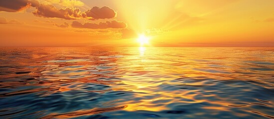 Fototapeta premium Sunset sky with orange and yellow sunlight over the sea creating a golden hour summer landscape with dusk sky and seascape as background for a copy space image