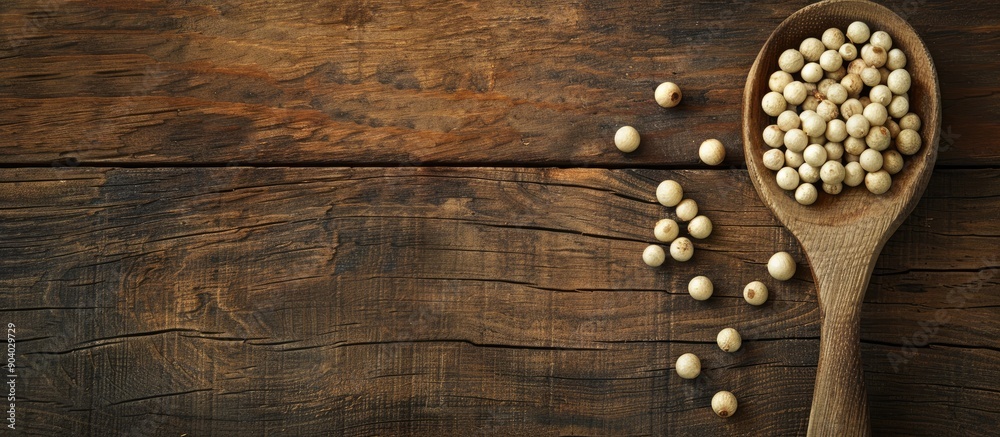 Poster organic white pepper corn in a wooden spoon displayed on a rustic wooden surface with a copy space i
