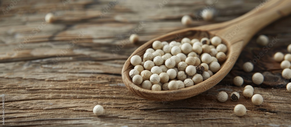 Poster organic white pepper corn in a wooden spoon displayed on a rustic wooden surface with a copy space i