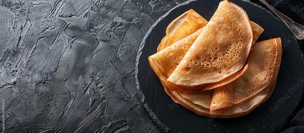 Poster tasty thin pancakes served on a sleek slate plate with copy space image