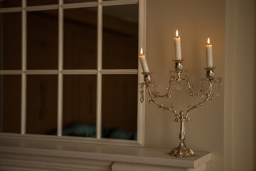 a silver candelabra with a white candles on top of it in a room