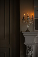 a silver candelabra with a white candles on top of it in a room