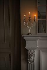 a silver candelabra with a white candles on top of it in a room