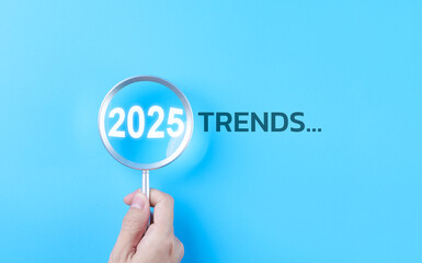 Trends 2025 year concept. Hand holding magnifying glass with 2025 trend searching bar for...