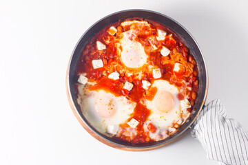 Shakshuka made of poached eggs in tomato pepper sauce